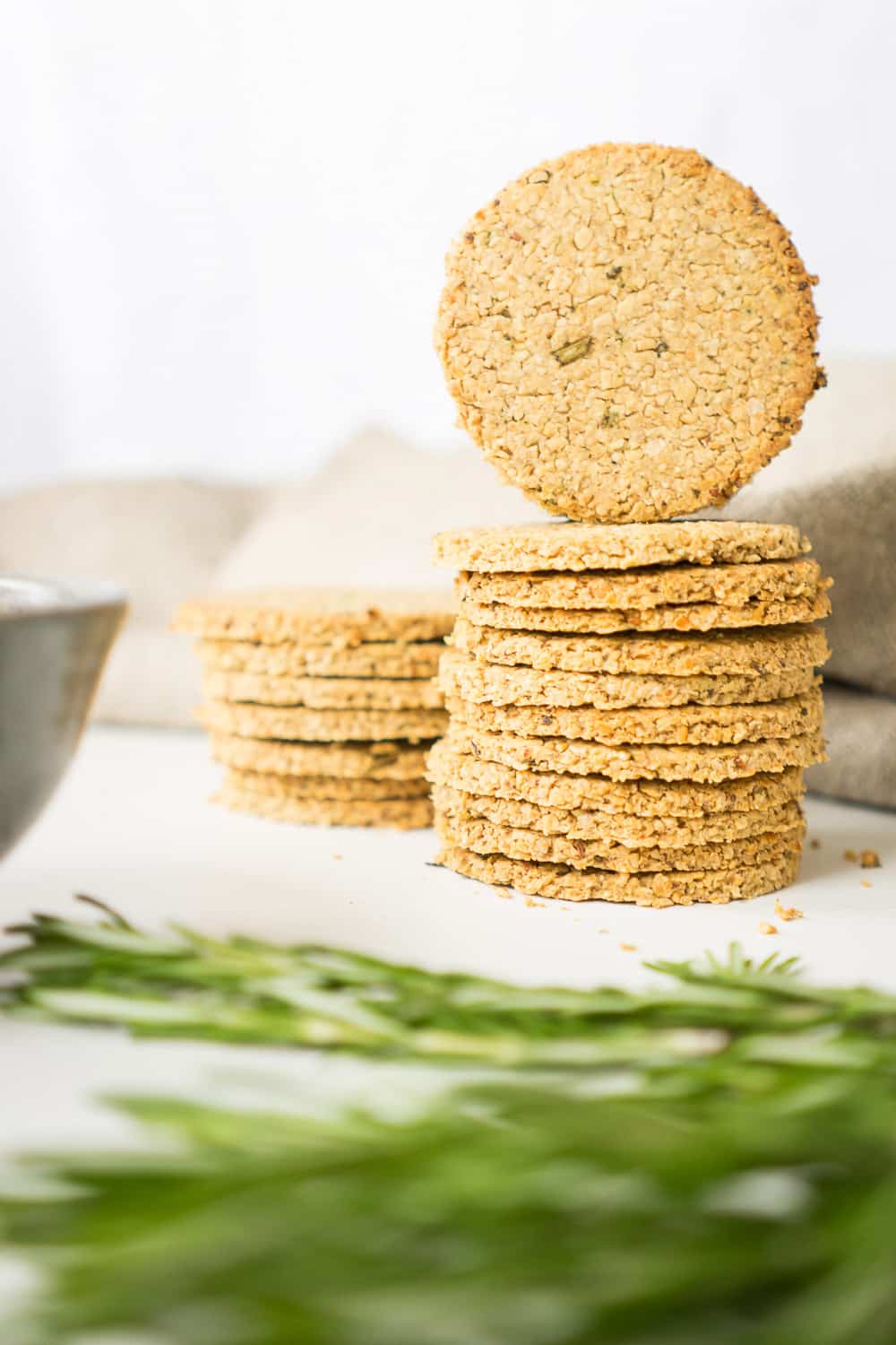 A pile of healthy oatcakes with rosemary branches in front of them.