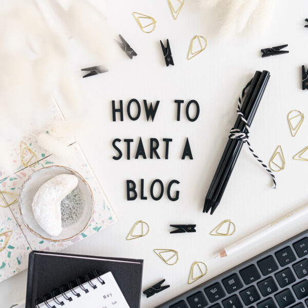 Desk with letters saying "How To Start A Blog"