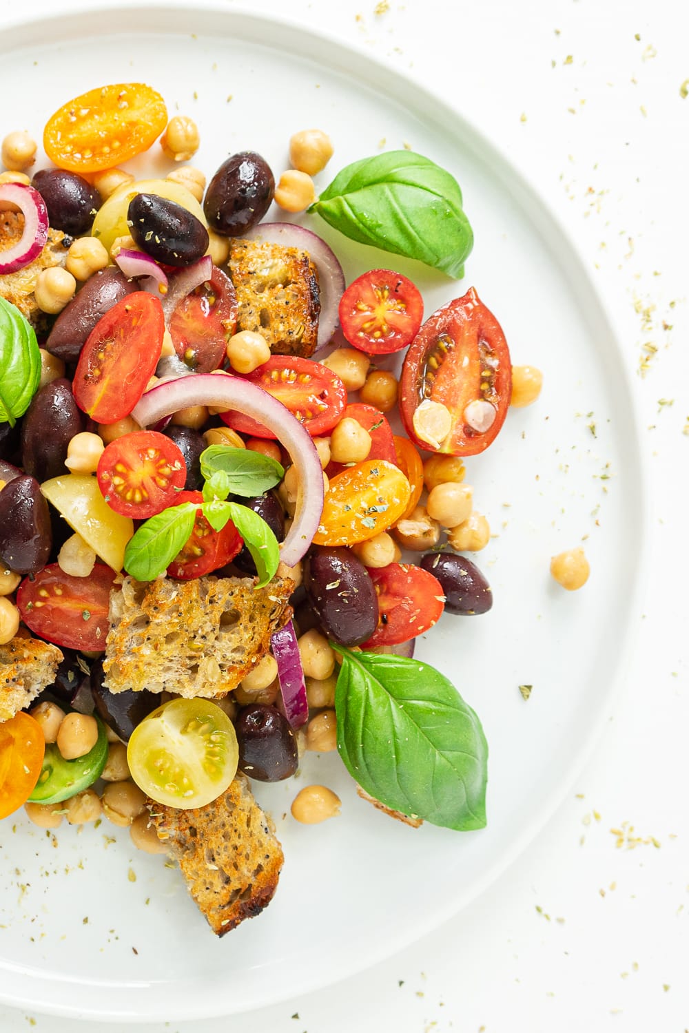 Tops view of Panzanella: Panzanella is a colorful and hearty Italian salad that puts to good use juicy tomatoes and stale bread. My take on this classic is perfect to prepare ahead!