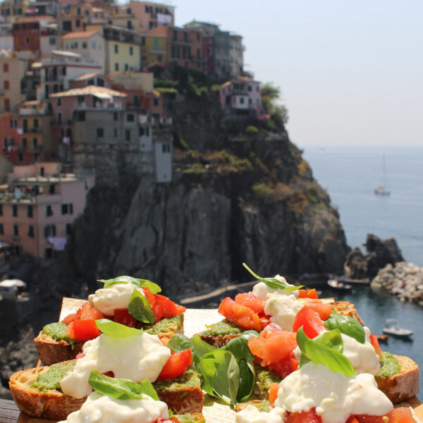 Bruschette with pesto from Nessun Dorma with Manarola in Cinque Terre in the background