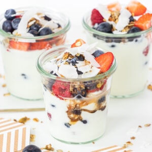 Fruit And Yogurt parfaits in glass jars with mixed berries