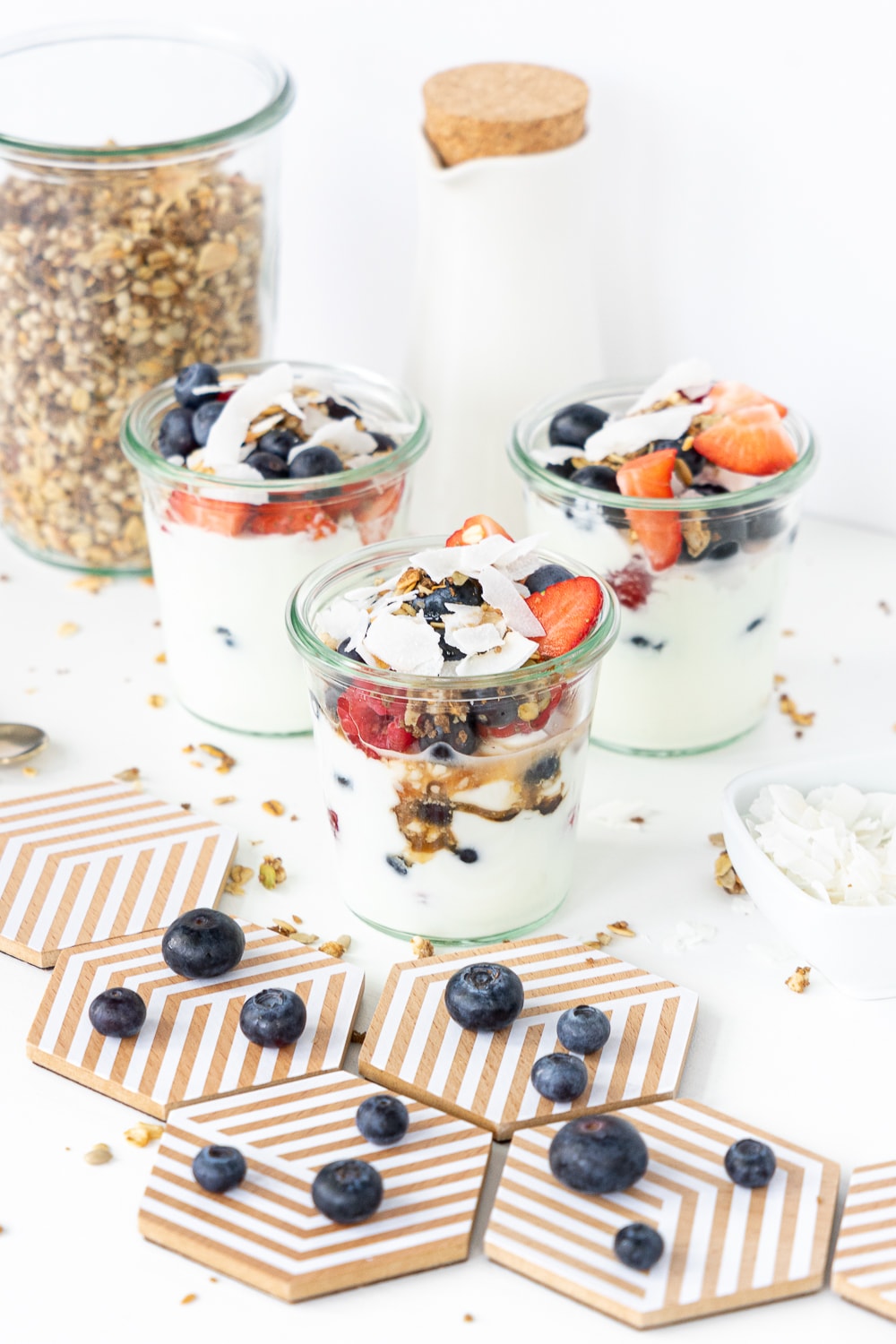 Yogurt parfaits in glass jars with mixed berries