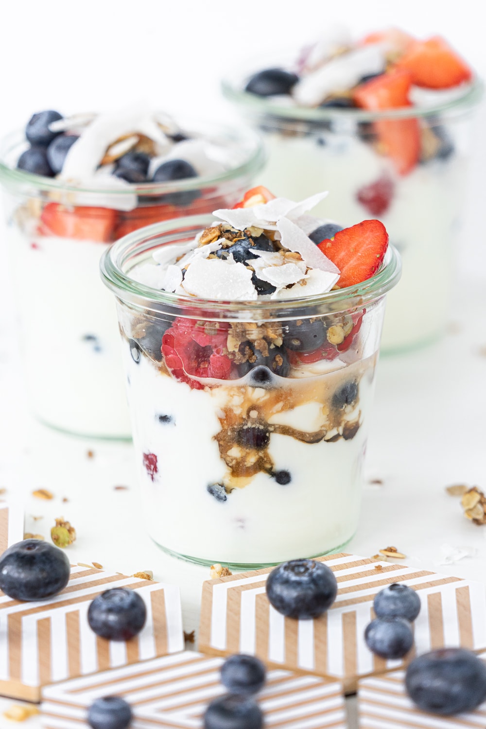 Close up of Yogurt parfaits in glass jars with mixed berries