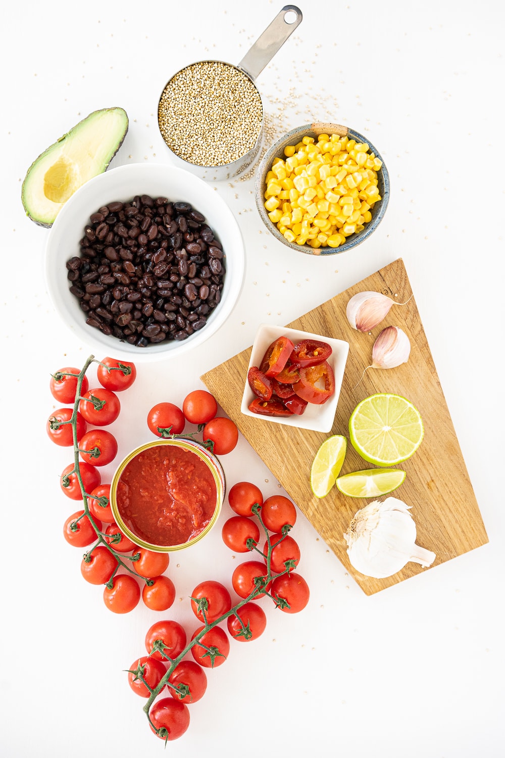 Top view of ingredients for Mexican quinoa: quinoa, black beans, corn, avocado, tomato sauce, garlic, jalape&ntilde;os 