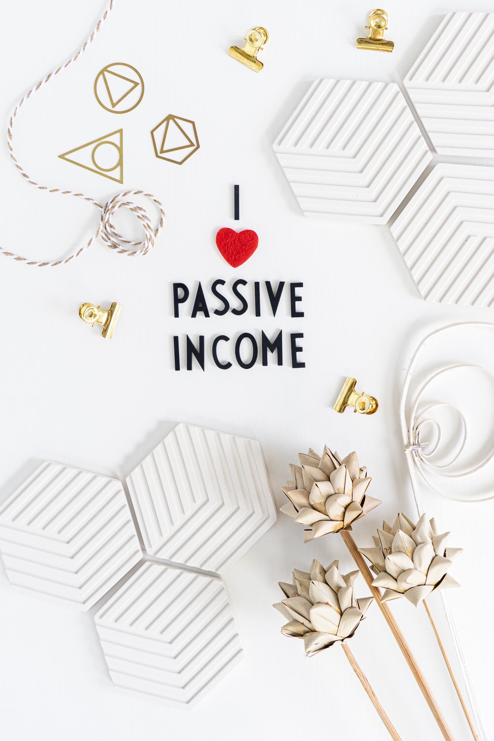 Flat lay with black letters on a white desk saying "I LOVE PASSIVE INCOME"