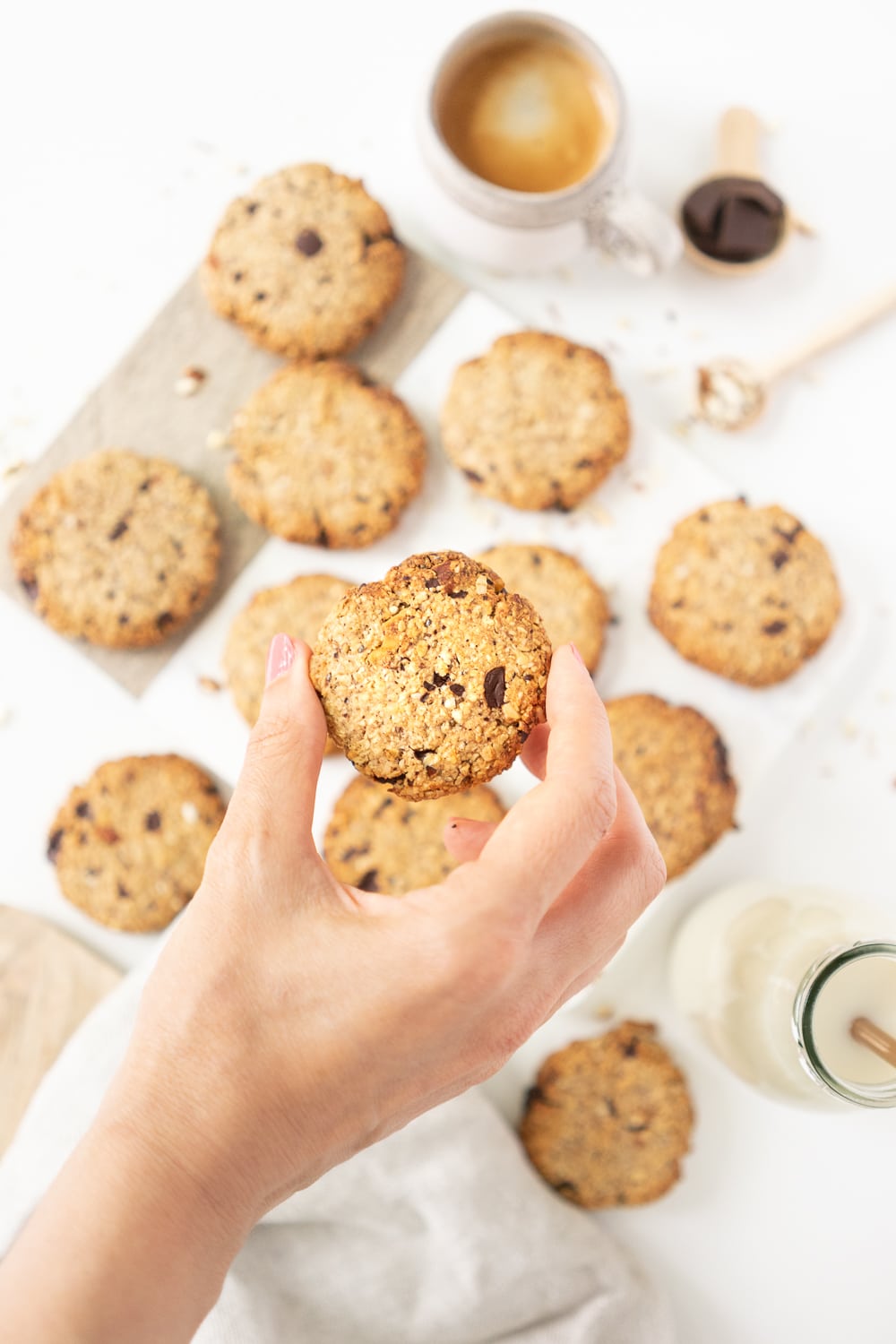 Hand holding a breakfast cookie with more cookies our of focus in the background