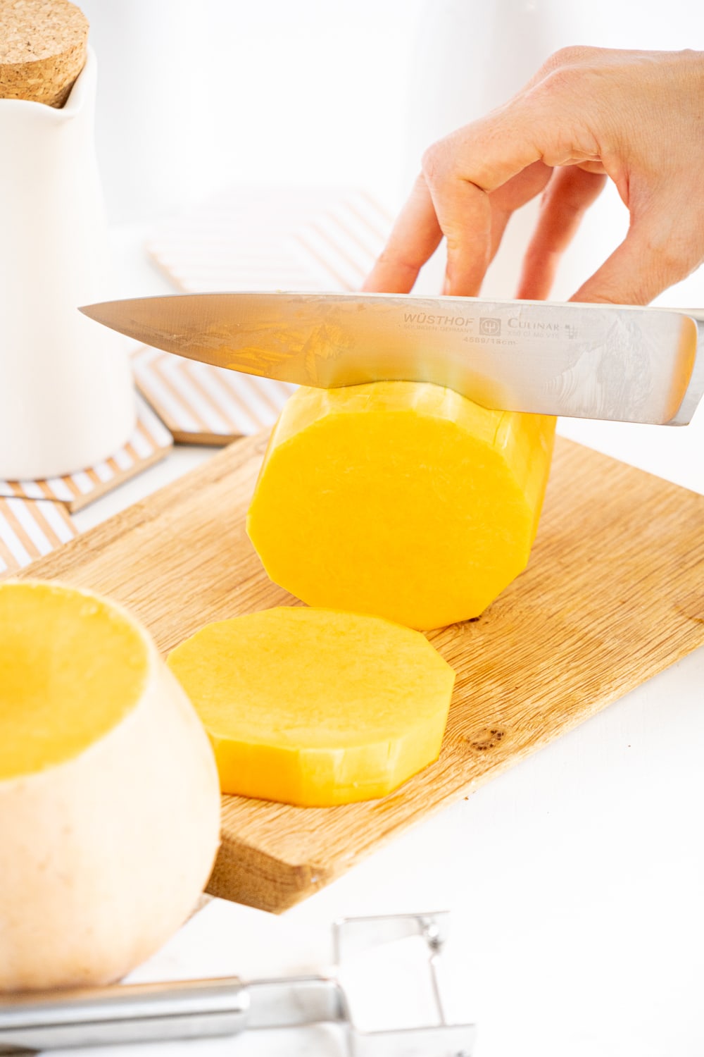 Hands cutting a butternut squash with a knife