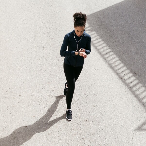 Woman walking, using an app to get paid to walk