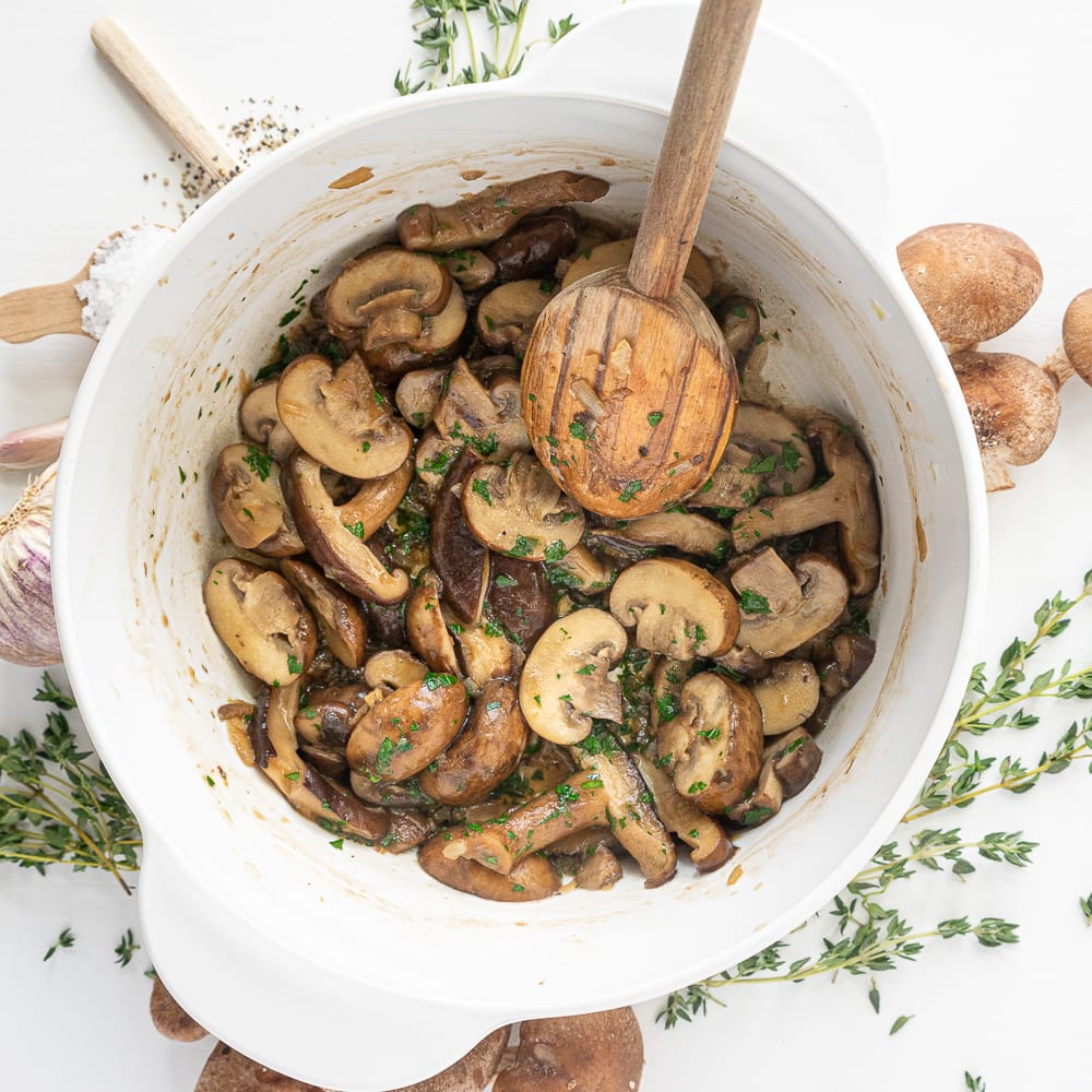 Top view of white pot with cooked mushrooms