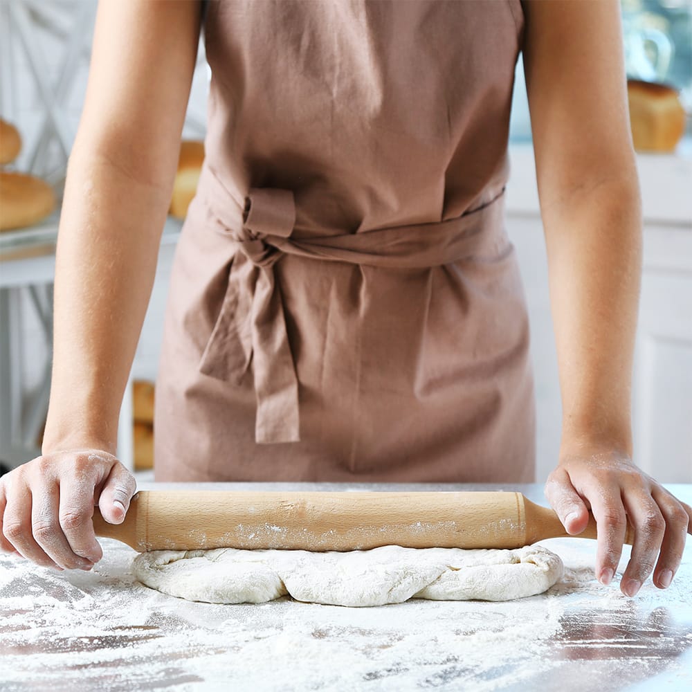 Baker sosteniendo un rodillo para preparar pan