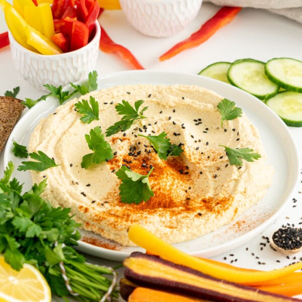 Easy hummus recipe on a white plate with veggies