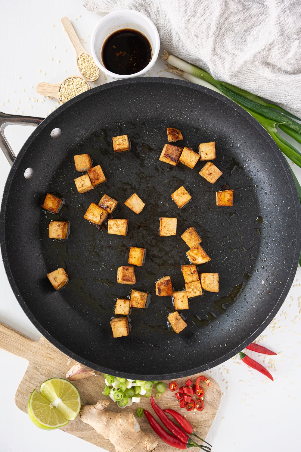 Tofu frying in a black pan