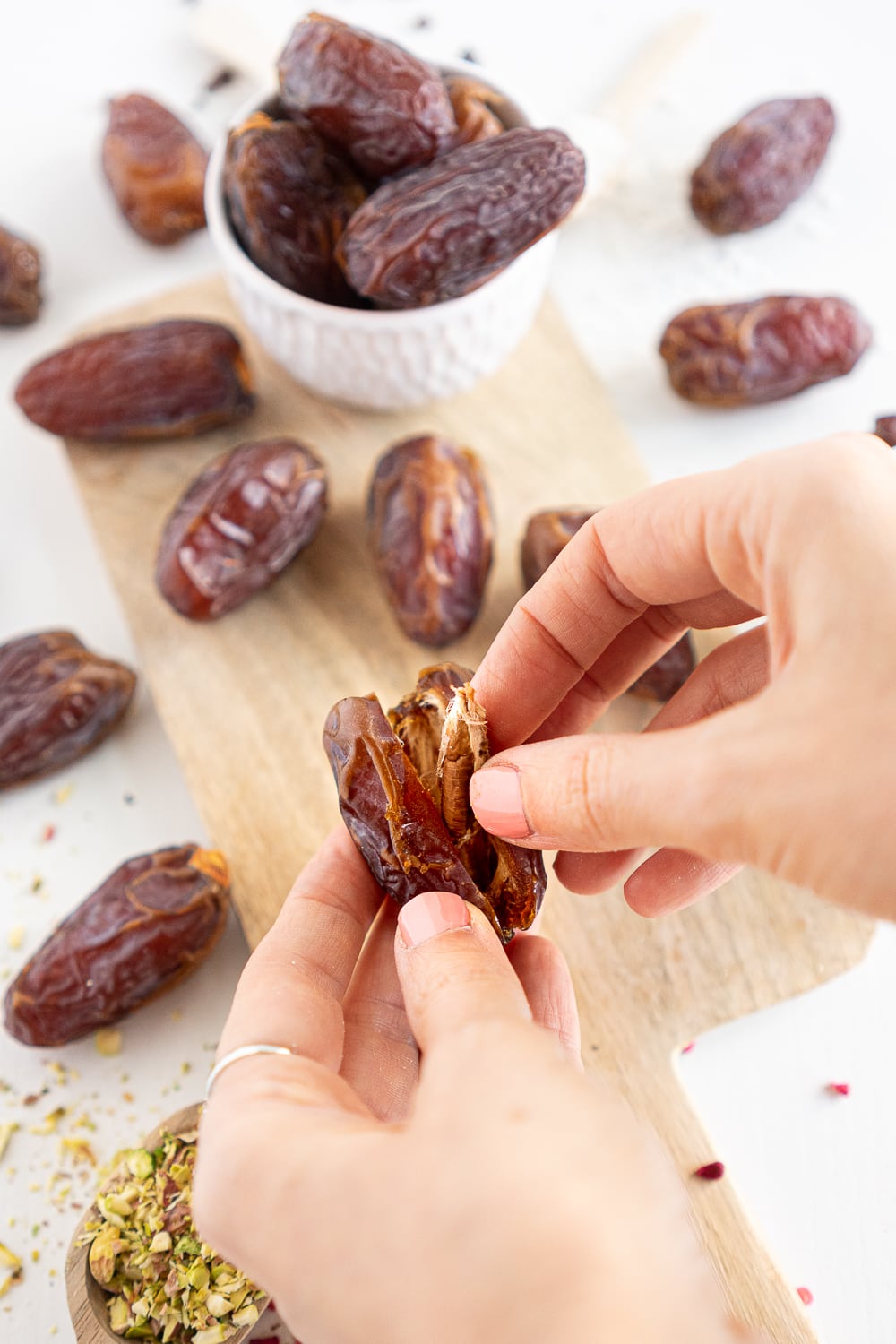 Hands removing the pit from a Medjool date
