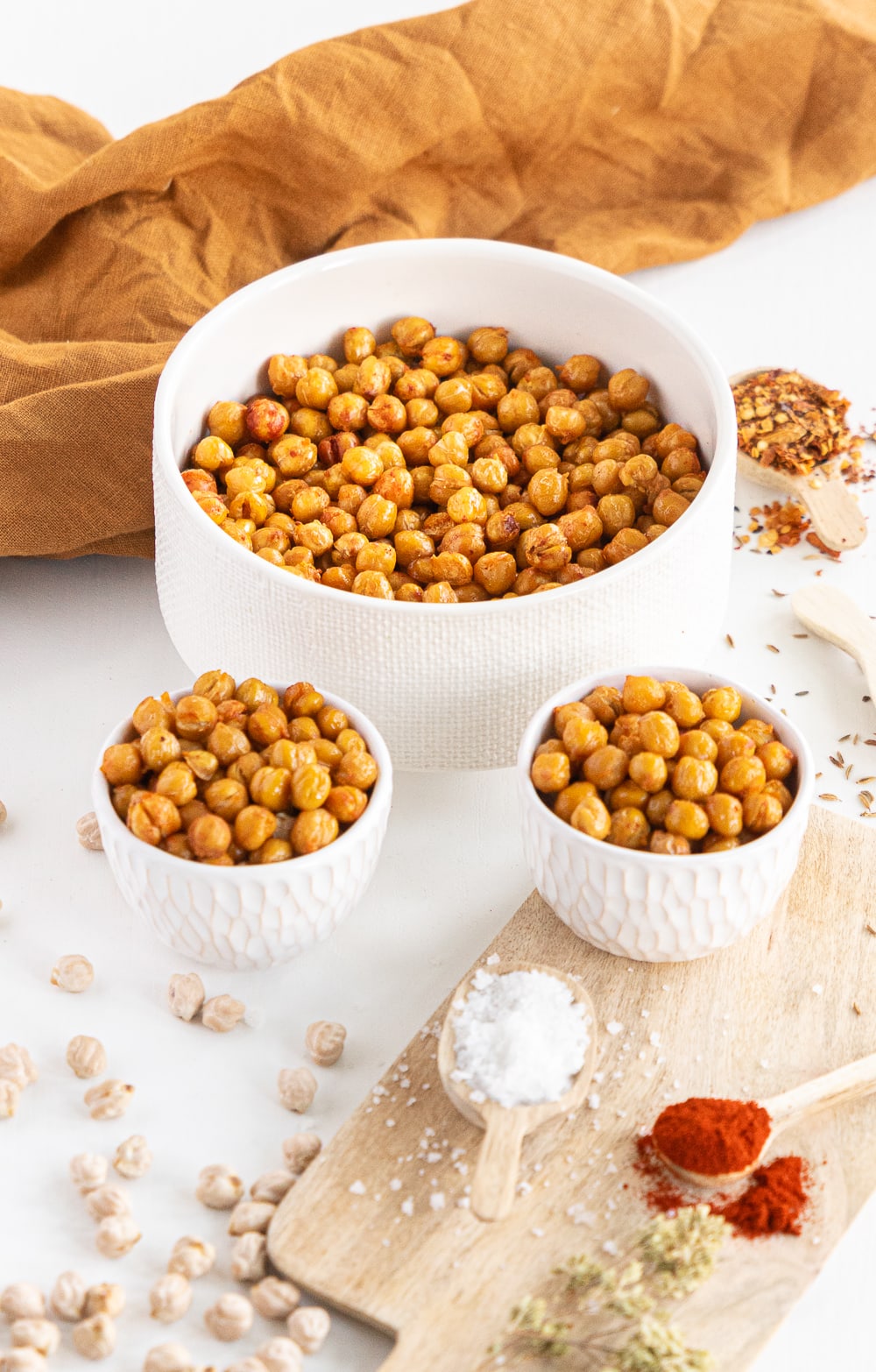 Wide view of 3 white bowls filled with crispy roasted chickpeas