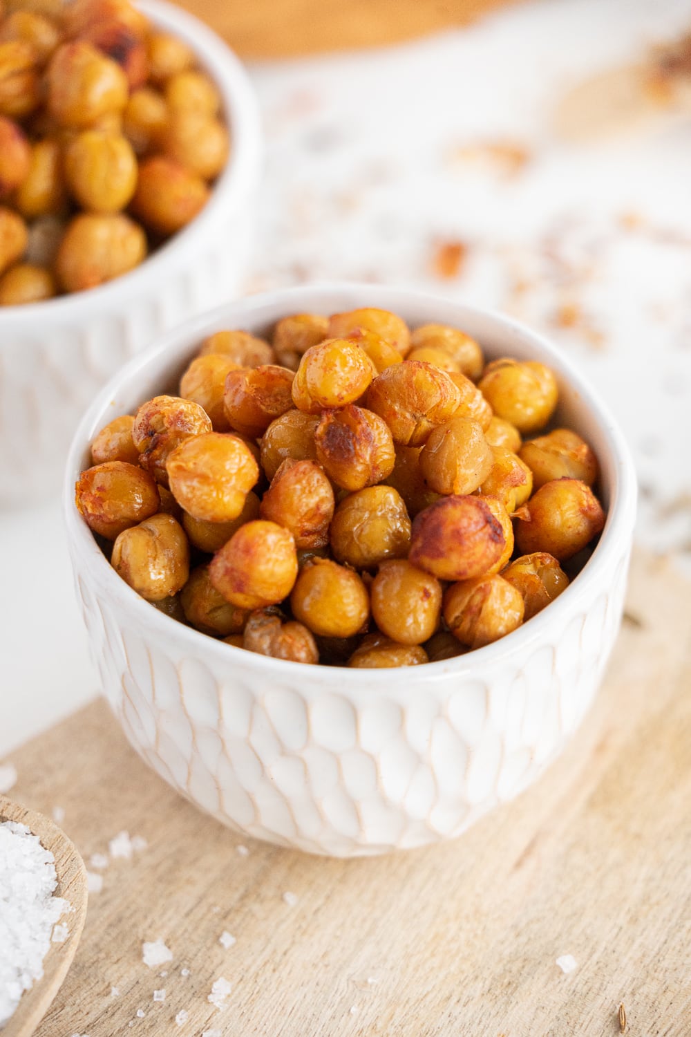Close up of a small white bowl full of roasted chickpeas