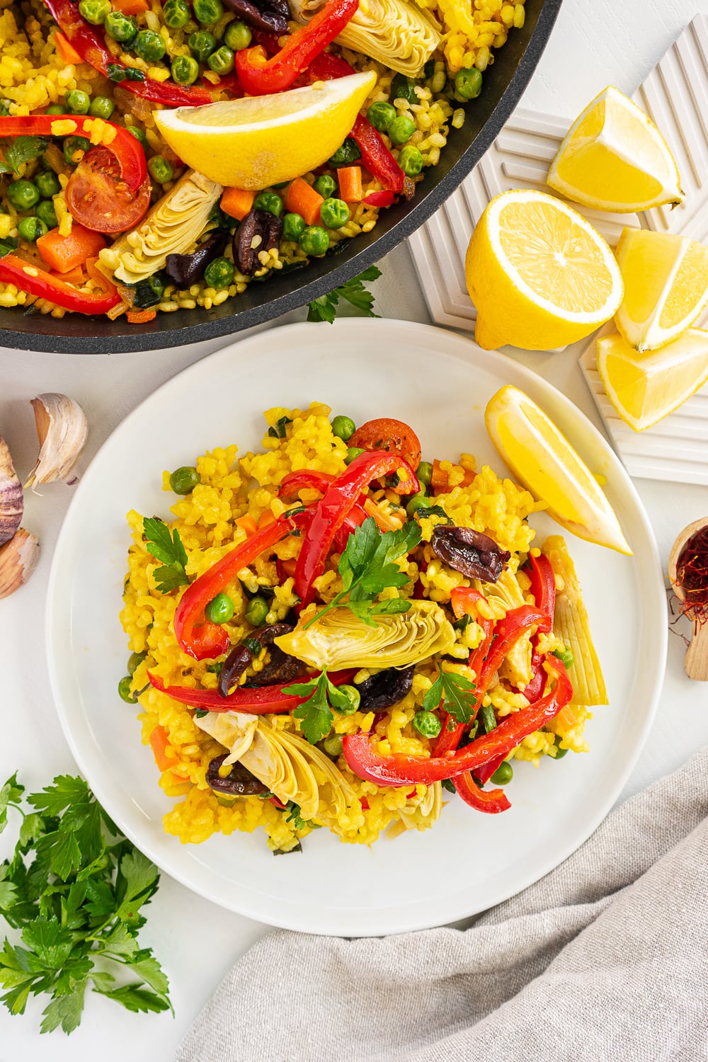 Top view of a plate and a pan filled with vegetarian paella