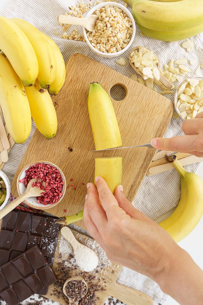 hands cutting a banana in half