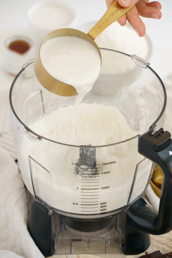 adding coconut milk in a food processor
