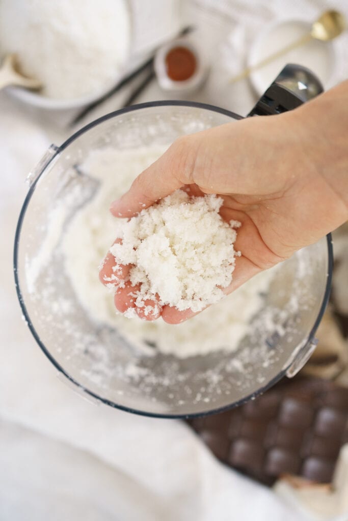 hand holding coconut mix in a food processor