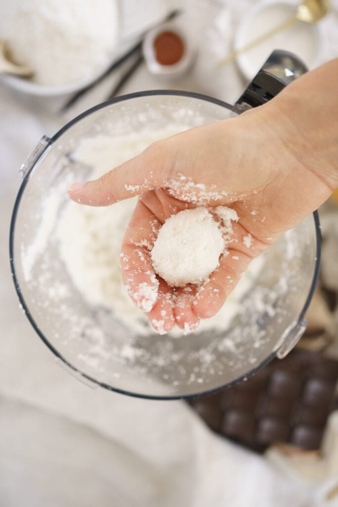 hand forming a bowl with coconut mixture