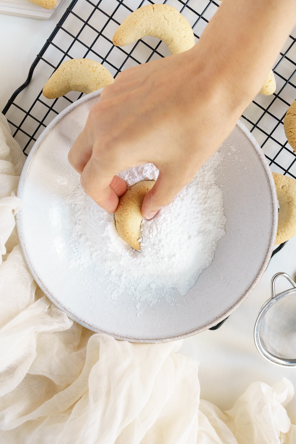 hand placing cookie in powdered sugar