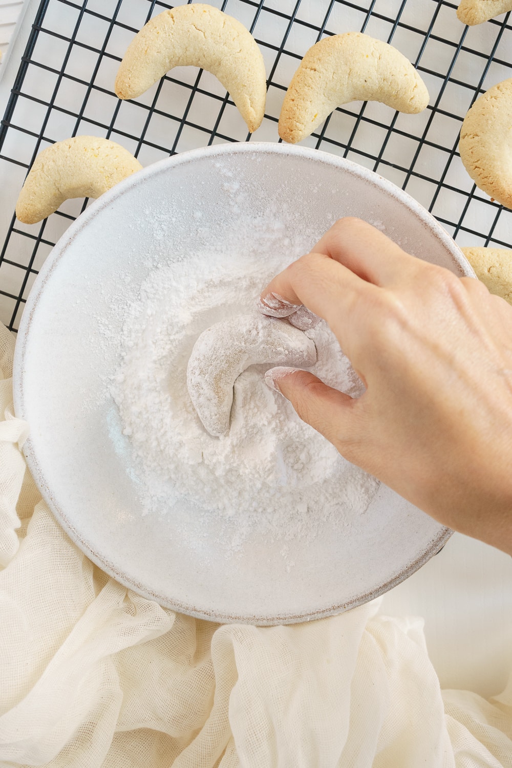 hand coating cookie in powdered sugar