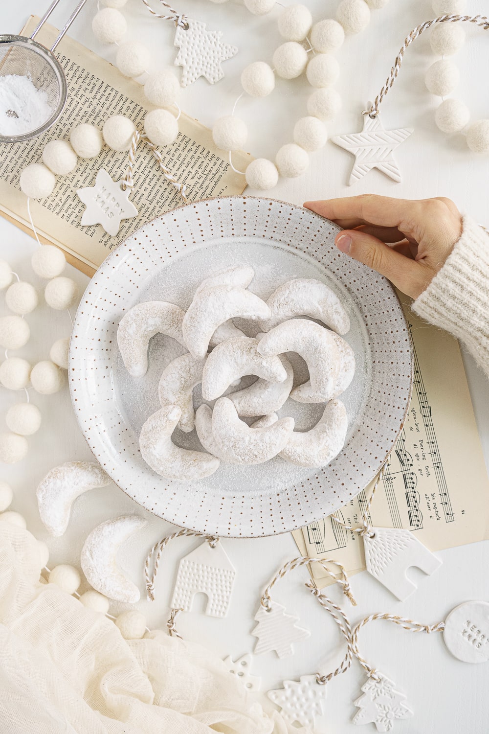 hand holding a plate filled with cookies