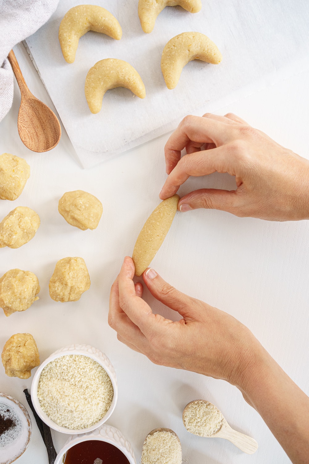 hand shaping crescent cookies