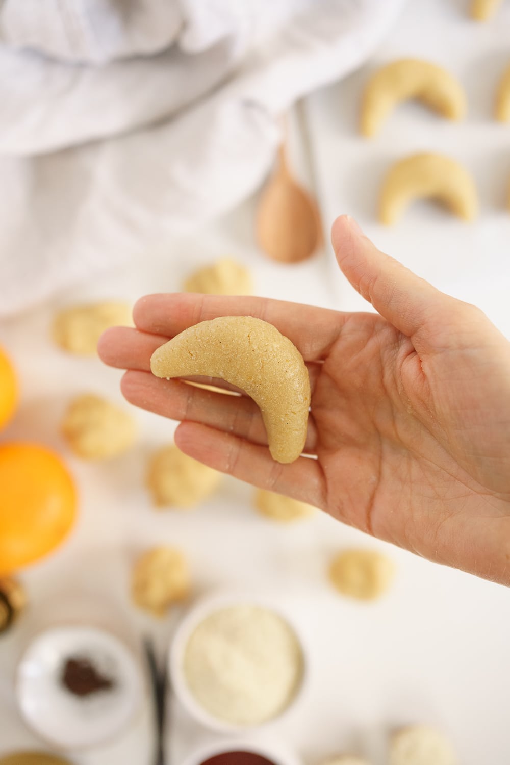 hand holding a cookie in a crescent shape before baking
