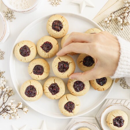 hand holding an almond thumbprint cookies