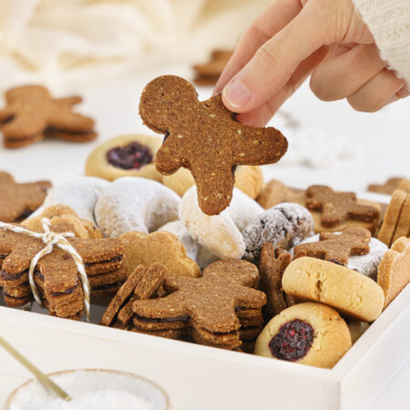 Hand holding a healthy Christmas cookie from a cookie box