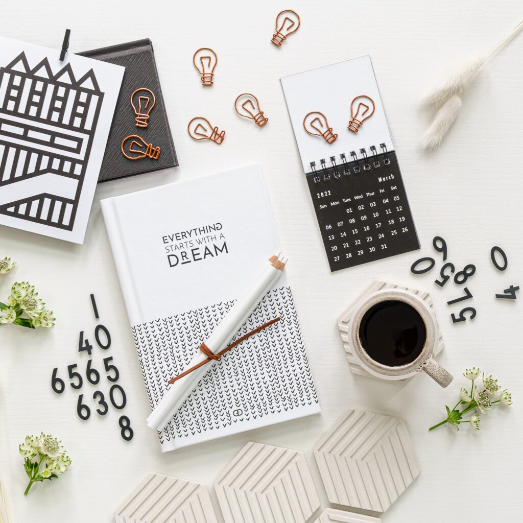 Close up of table with everything starts with a dream book and calendar