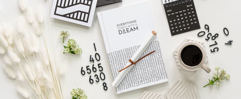 Everything starts with a dream book on table with office supplies