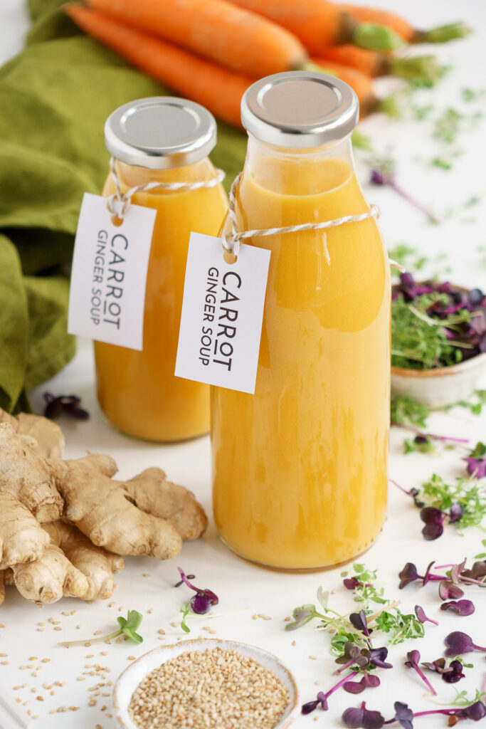 Vegan carrot ginger soup in glass bottles