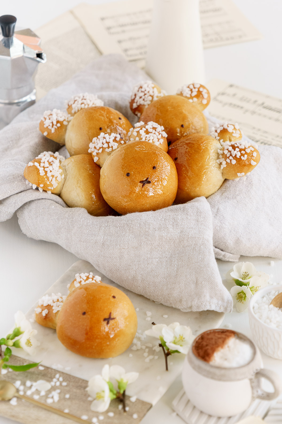 Basket of Easter vegan brioche bunnies on the table with flowers and table setting.