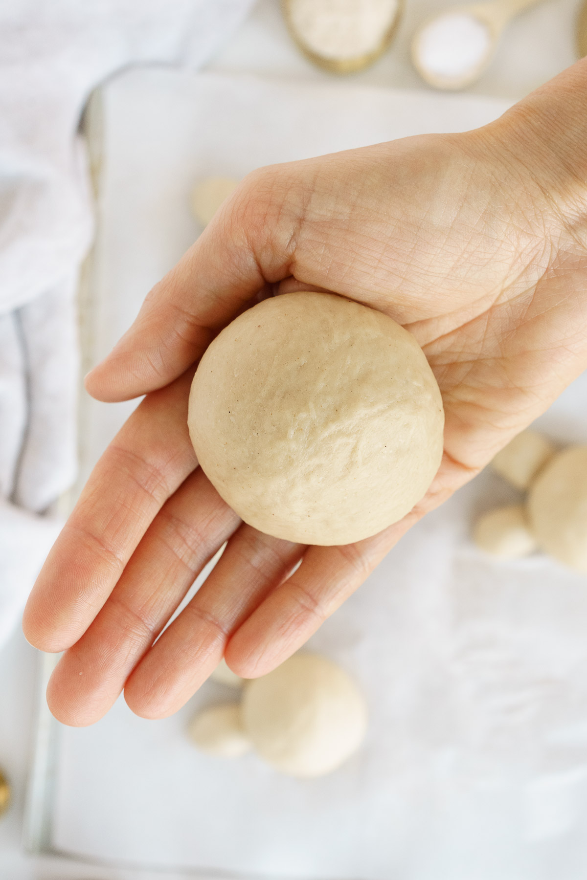 Ball of dough in the palm of a hand.