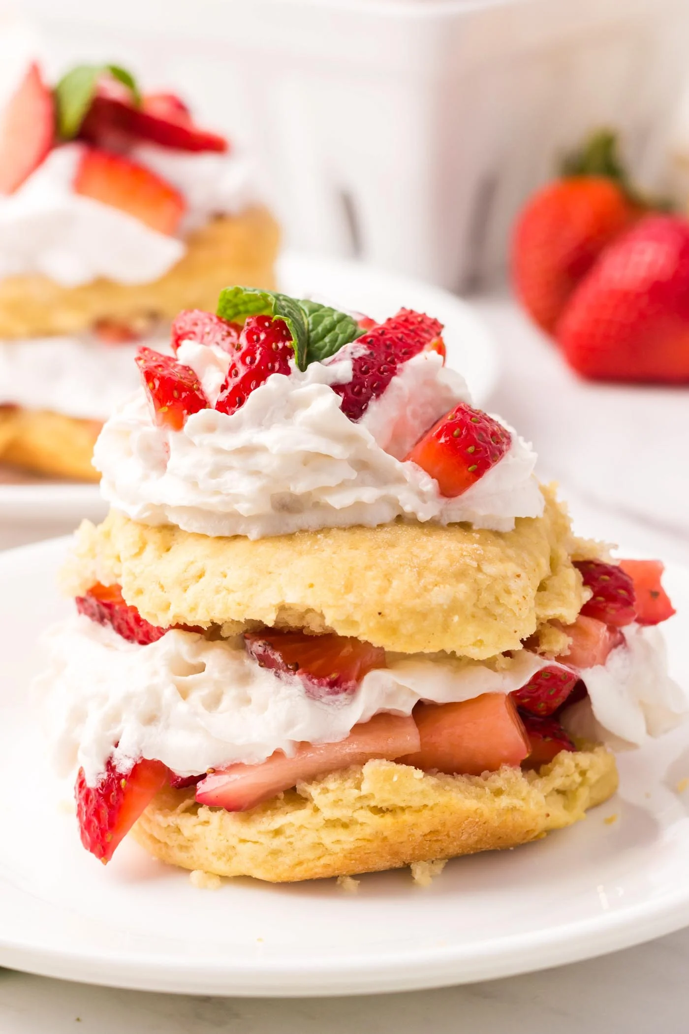 Side view of fluffy vegan strawberry shortcake filled with strawberries and cream