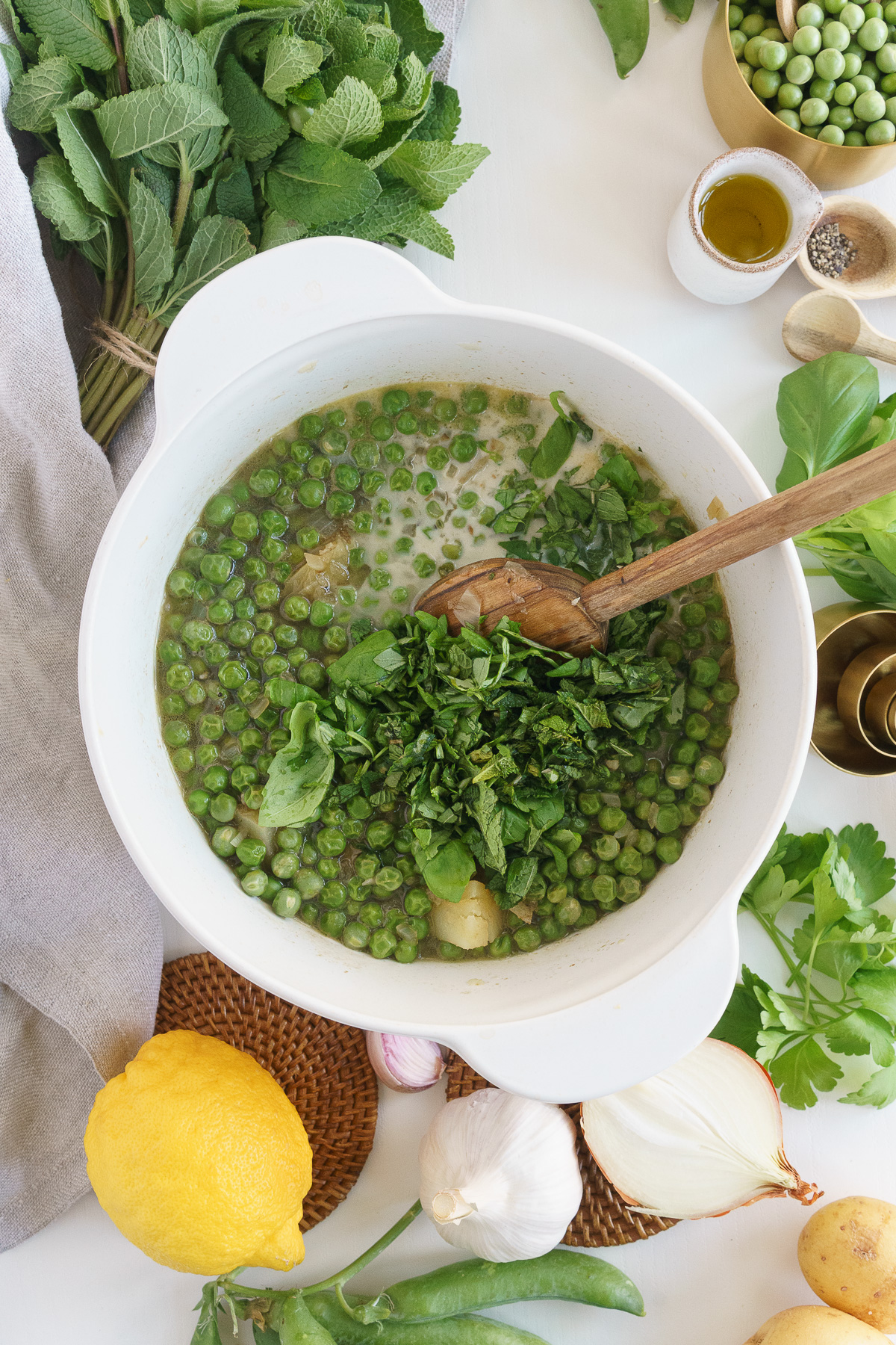Adding the herbs to the fresh pea soup.