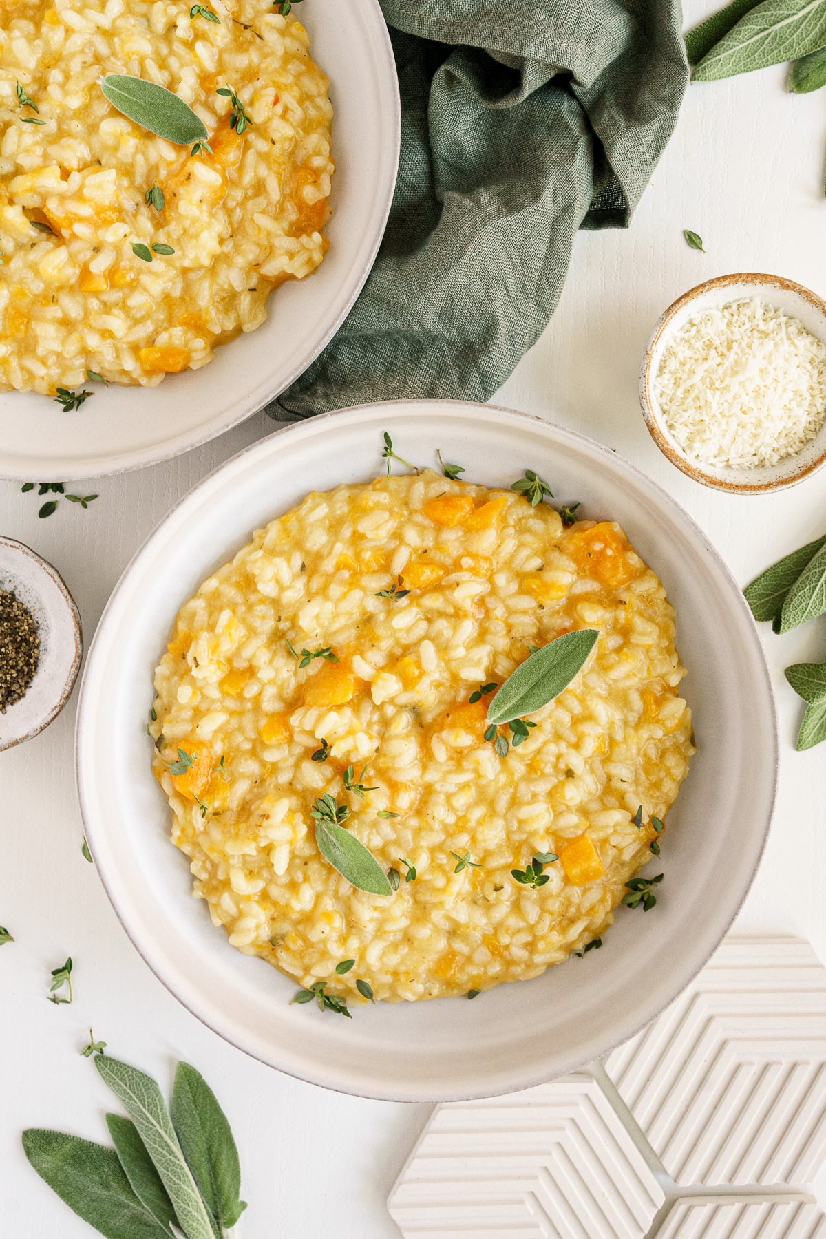 Bowls of butternut squash on the table with fresh sage ganish.