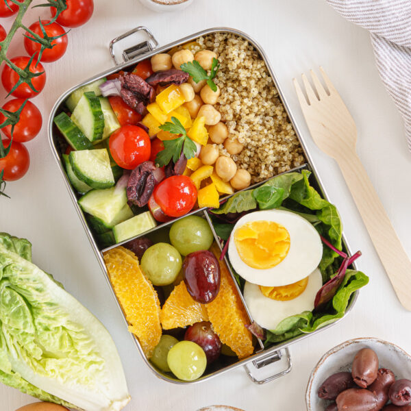 Vegetarian bento box with boiled eggs, veggies and grapes.