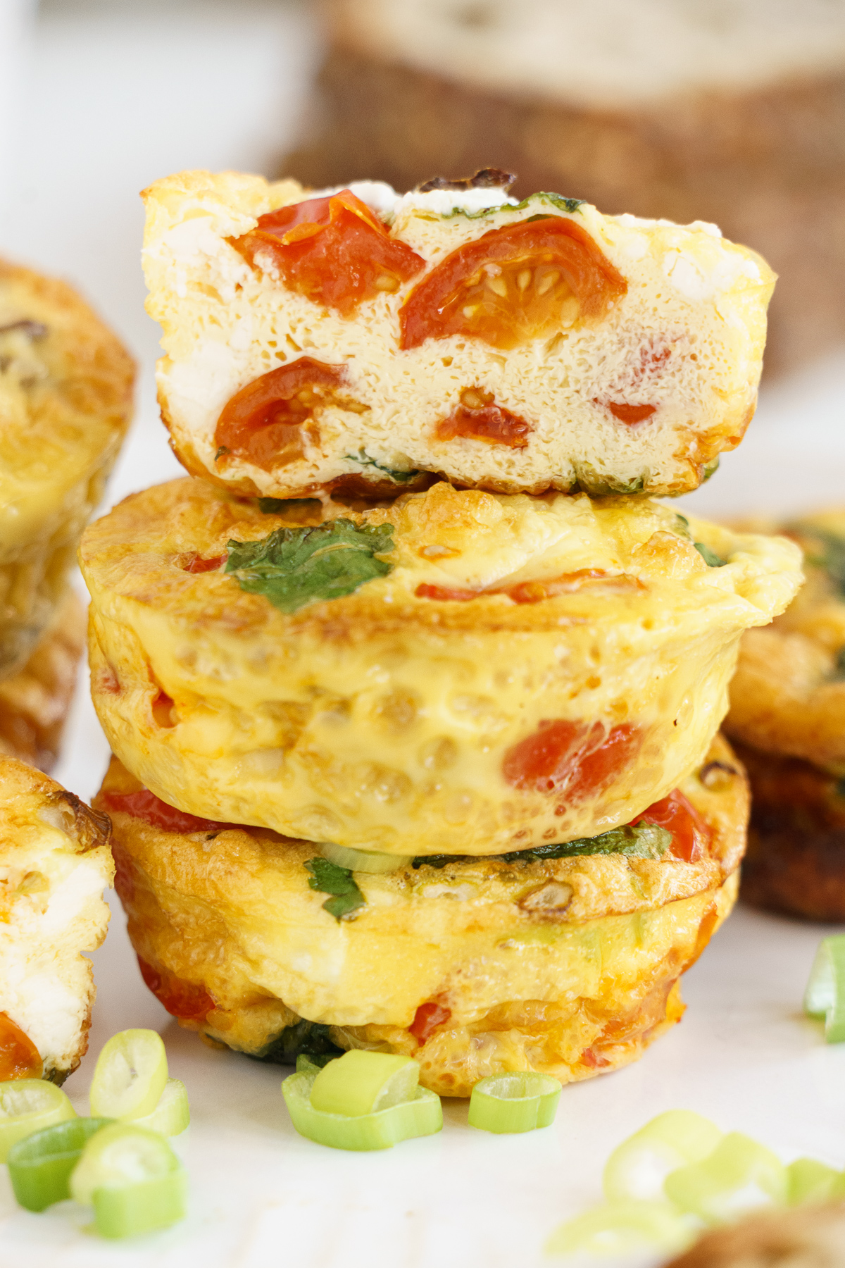 Stack of breakfast egg muffins with one cut in half to show inside.
