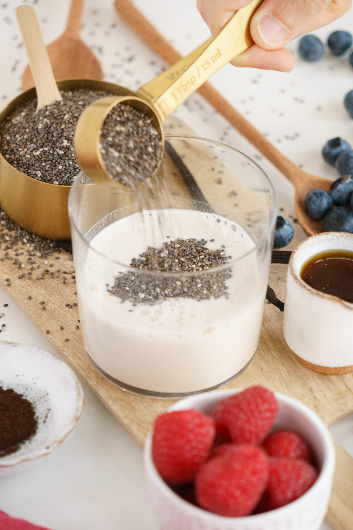 Adding chia seeds to coconut milk to make chia pudding.