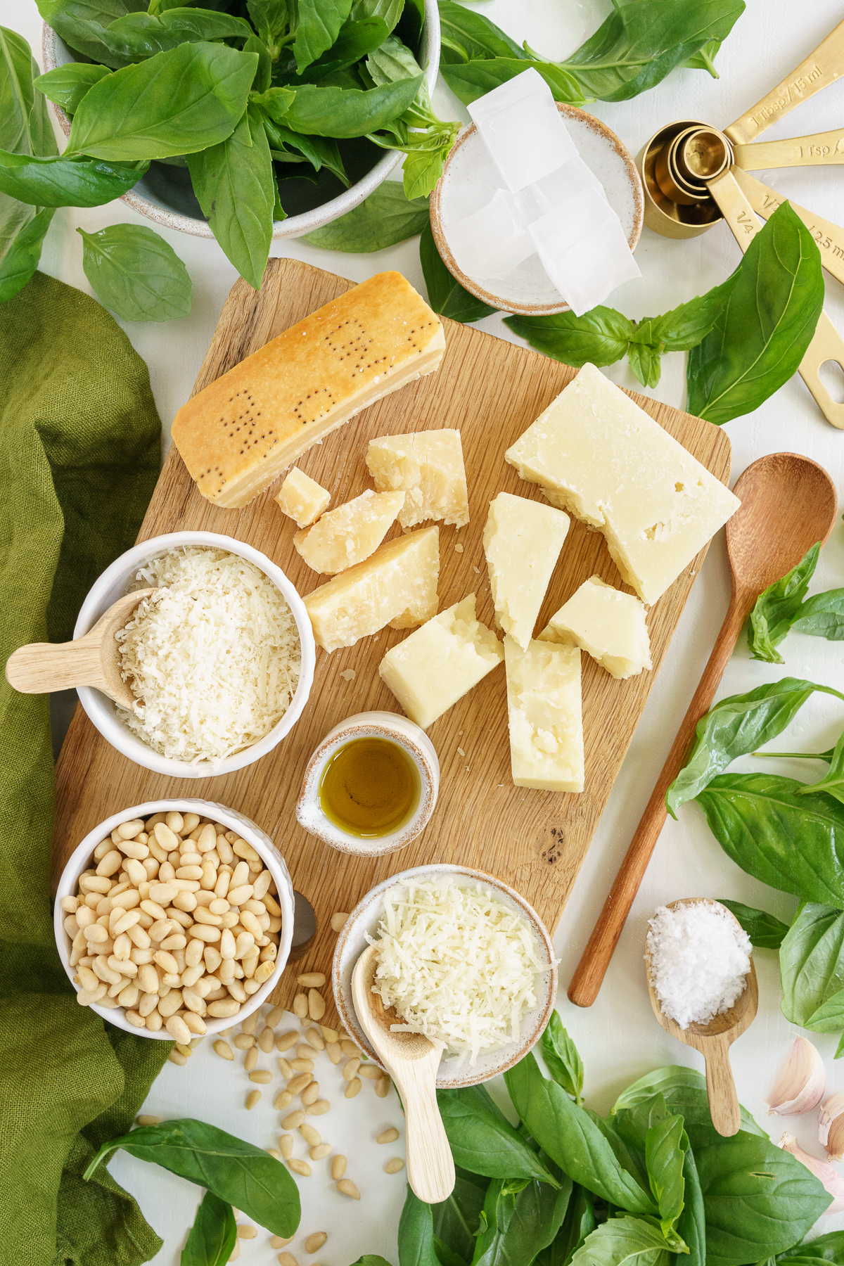 Ingredients to make genovese pesto on a cutting board and the table.