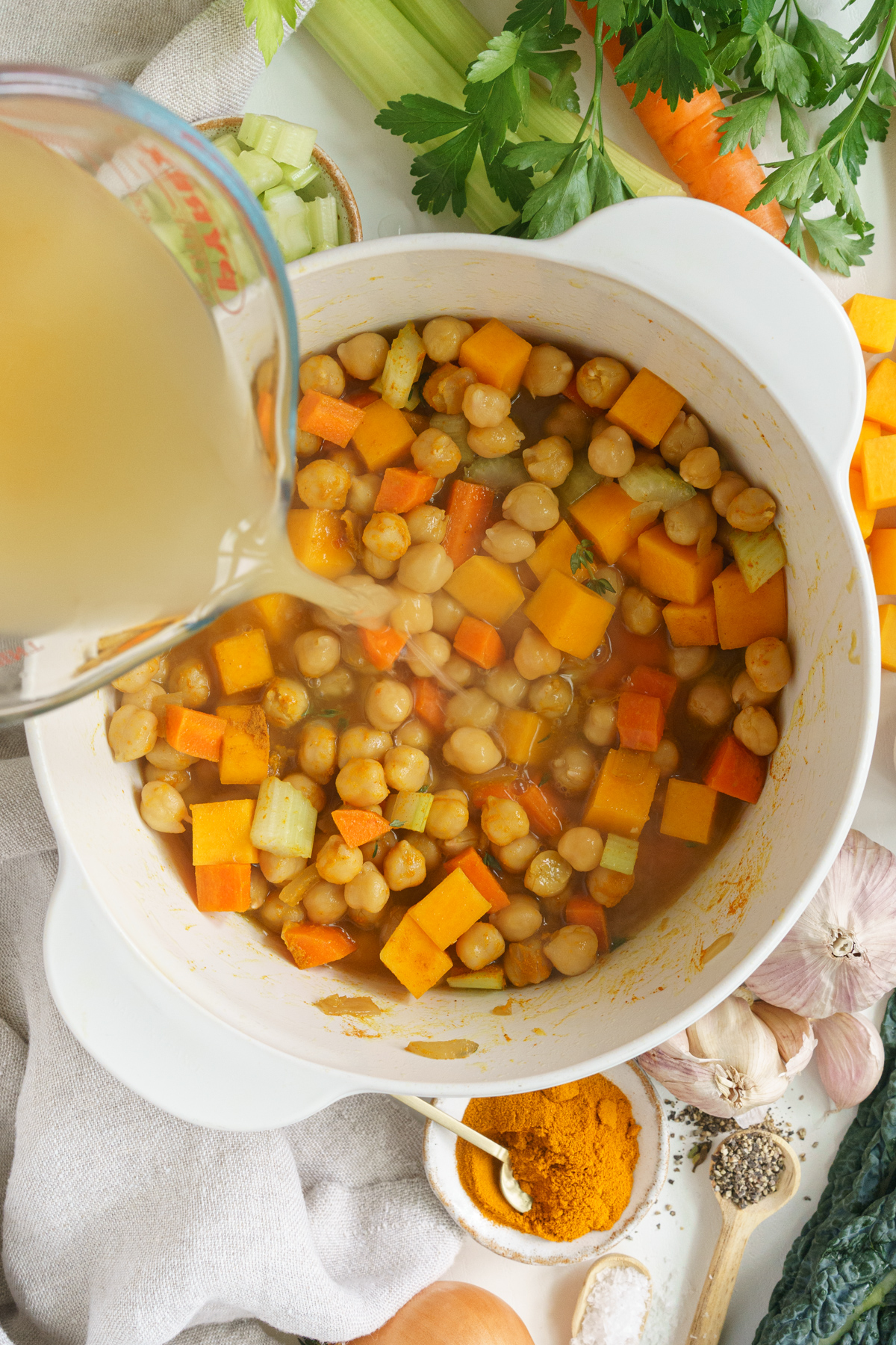 Adding the vegetable broth to the pot.