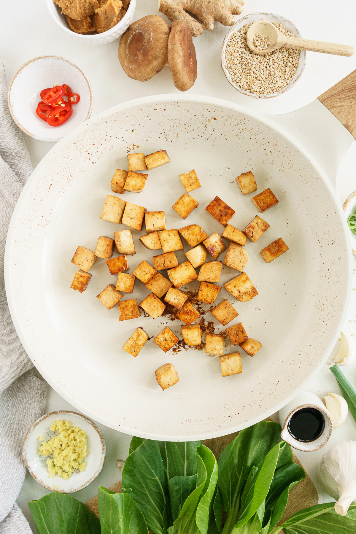 Top view of tofu cooking in a white pan