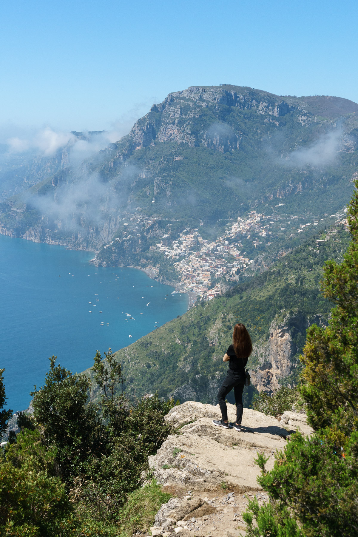 Girl on a rock admiring Positano from afar