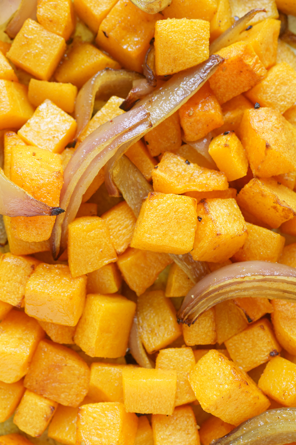 Close up of cooked butternut squash with forks picking some up.