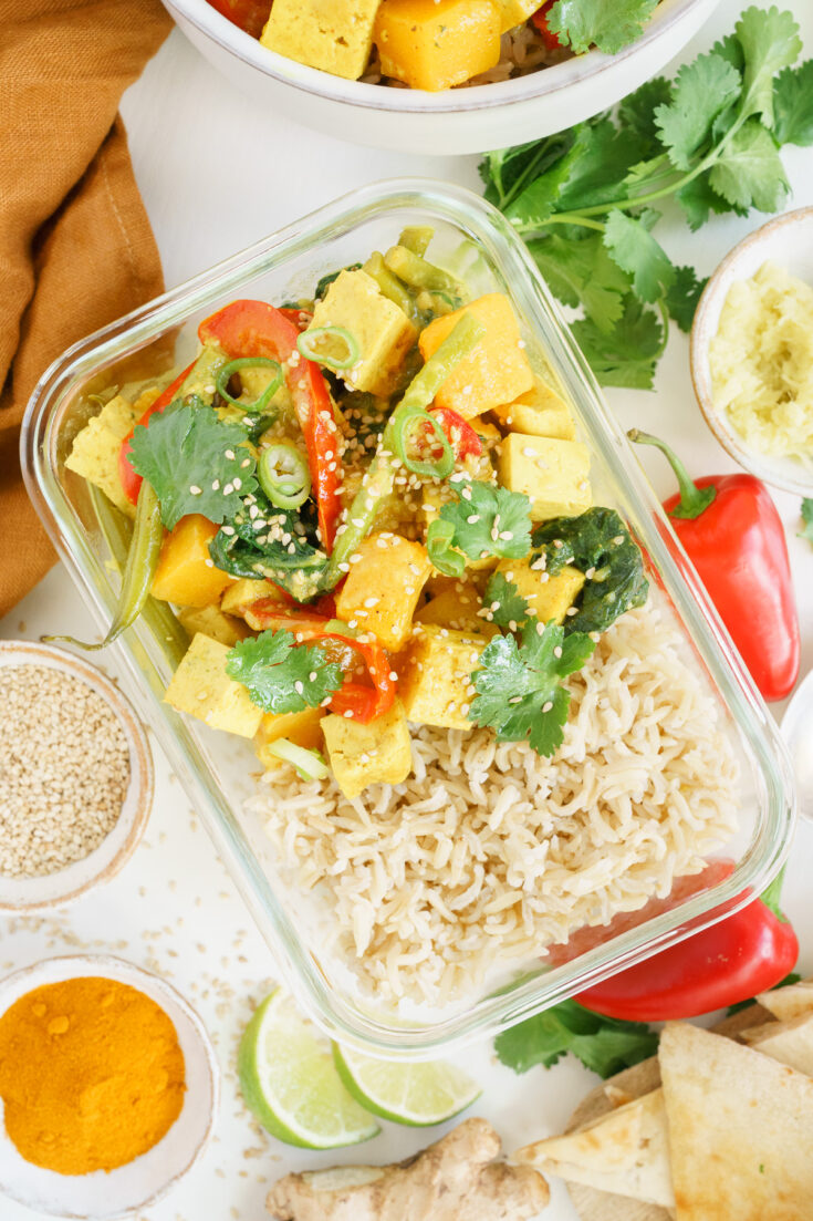 Top view of tofu curry in a glass meal prep container