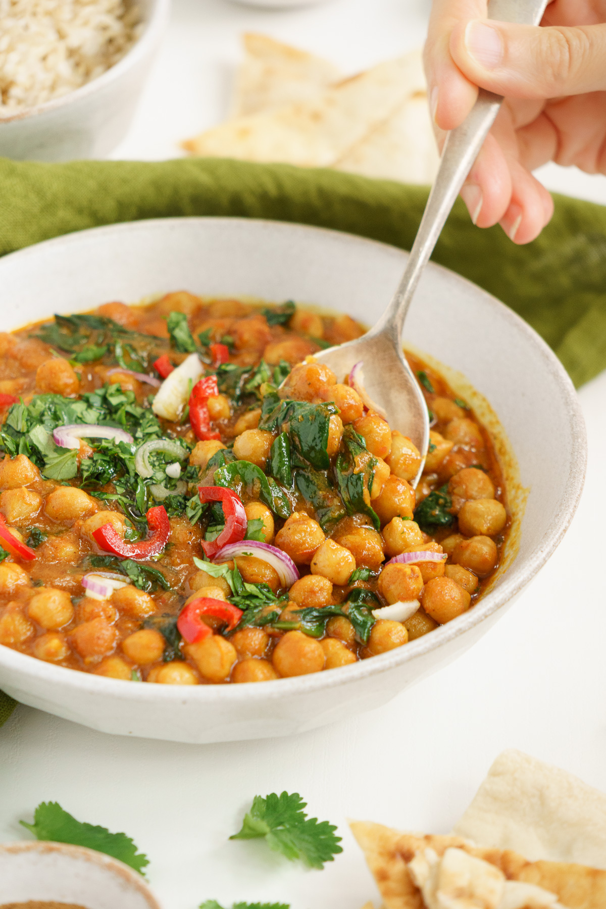 Spoon dipping into a vegan chickpea curry.
