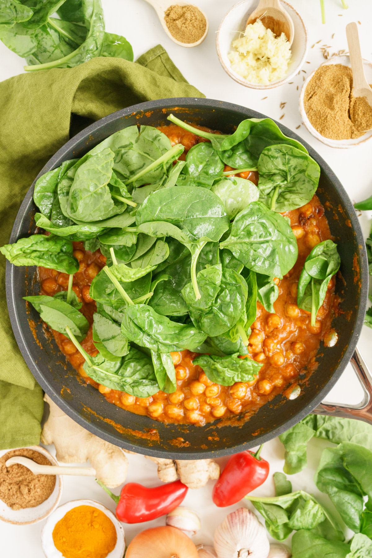 Adding the greens to the chickpea curry.
